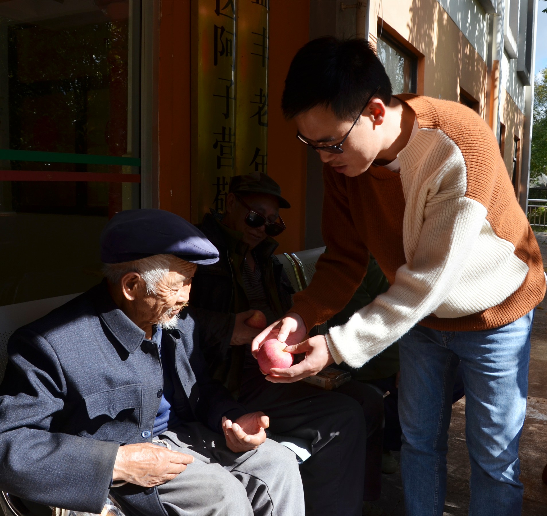 常党先生将昭通糖心苹果送到老人手中